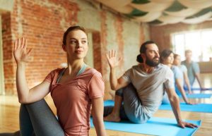 two people practice yoga in yoga class and have experienced the benefits of yoga in addiction recovery