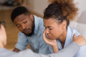 a man talks to a woman who is crying about how to help an alcoholic family member