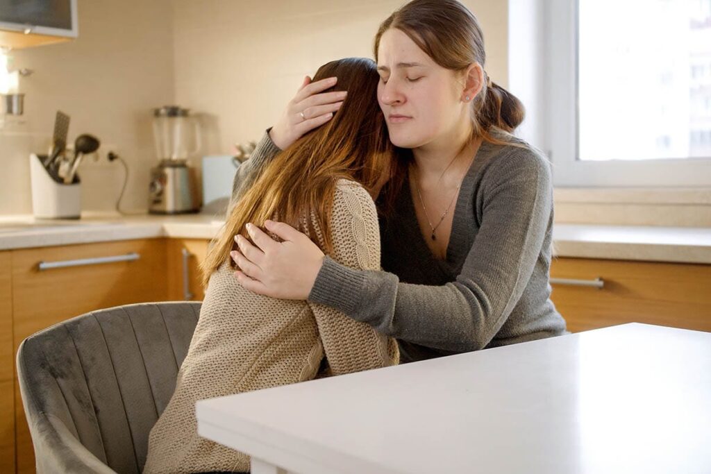 mother comforting her adult child in addiction recovery