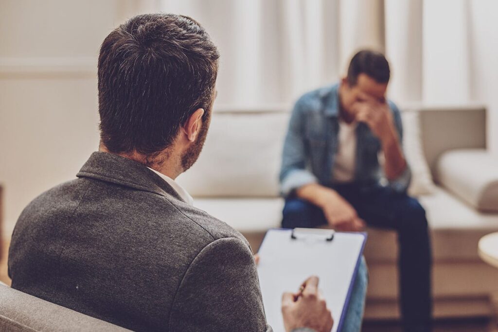 therapist talking to male patient about the benefits of partial hospitalization programs