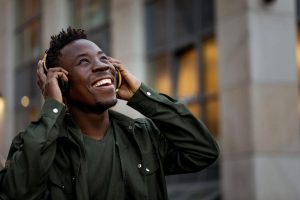 man smiling and listening to music on headphones enjoying life after rehab