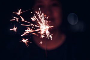 a person holds a sparkler and learning how to have a sober new year's eve