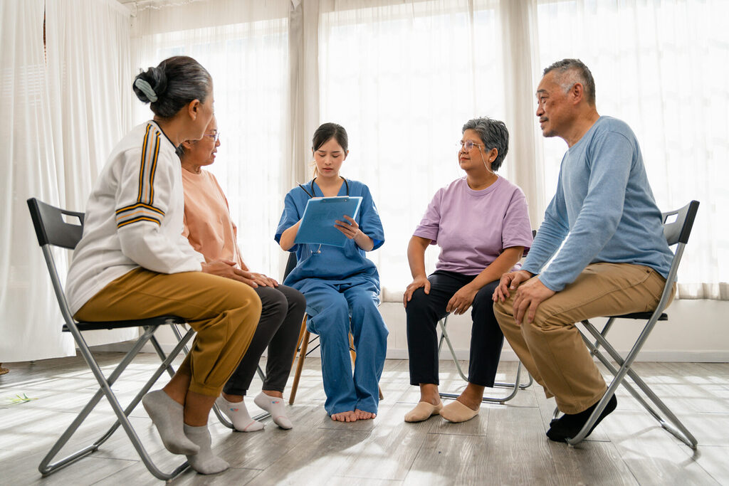 old people sitting in a circle participating in group therapy