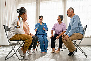 old people sitting in a circle participating in group therapy