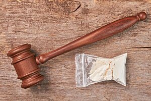 Packet of drugs gavel wooden background