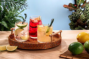 Sparkling cocktails with ice and citrus on a wicker tray Popula