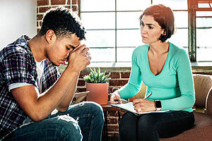 woman in blue shirt talks with man about starting an anxiety treatment program in texas