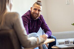 man talks with therapist in a men's rehab program