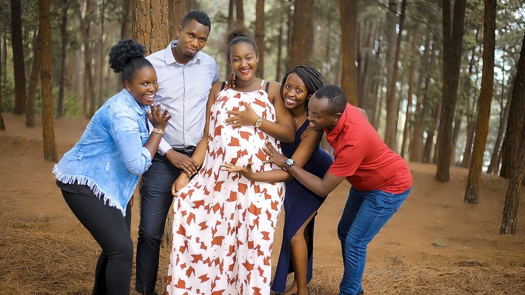 A family doing a pregnancy photo shoot in the woods