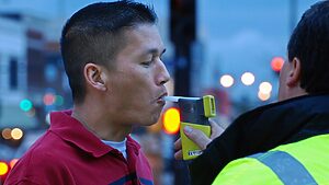 A citizen being breathalyzed to check their BAC